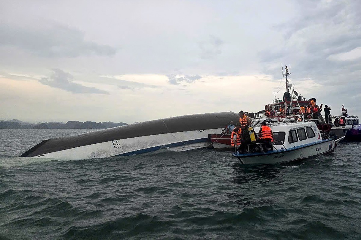 relief personnel gathered around a capsized tourist boat (L) during a search and rescue operation in the Ha Long Bay, Quang Ninh province. At least 18 people have died and dozens remain missing after a tourist boat carrying more than 50 people capsized on July 19