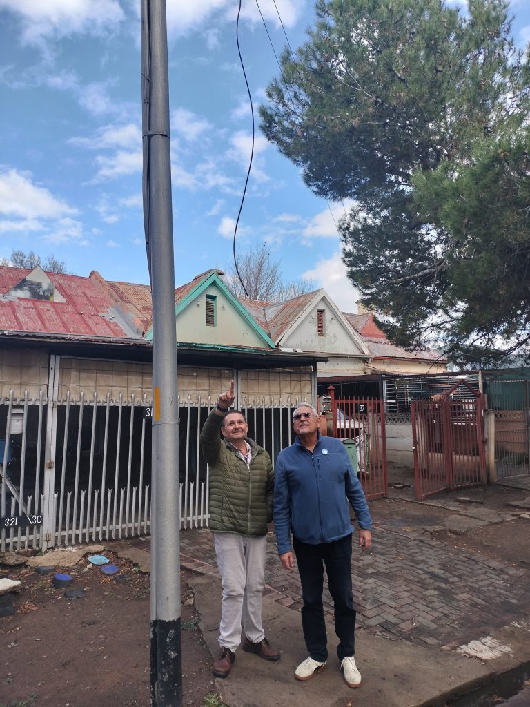 Ds. Jannie Smith (links) en wyksraadslid Pieter Lotriet by die kragpaal oorkant die inwoners se huis.
