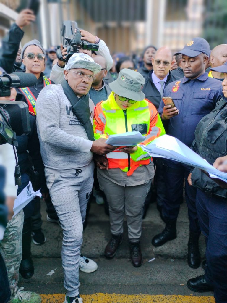 Die premier MaQueen Letsoha-Mathae teken ontvangs van die versokskrifte. 