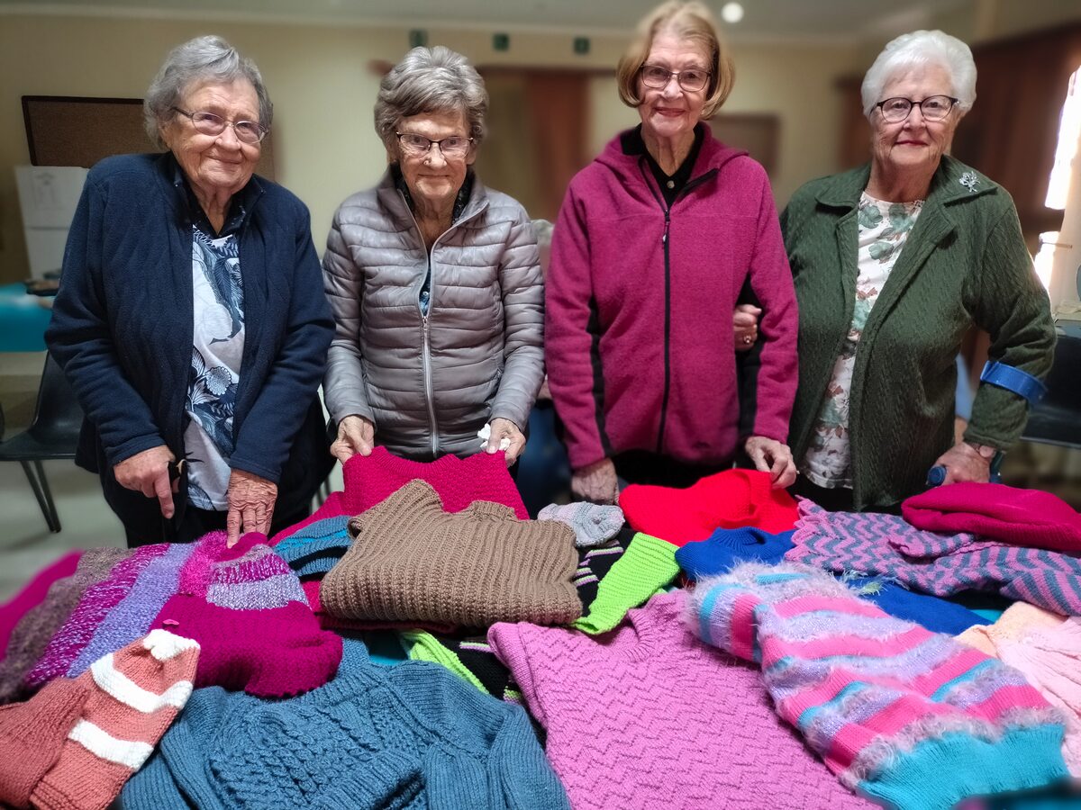 Vier van die vroue wat hard gewerk het aan die projek om truie vir kinders te brei.