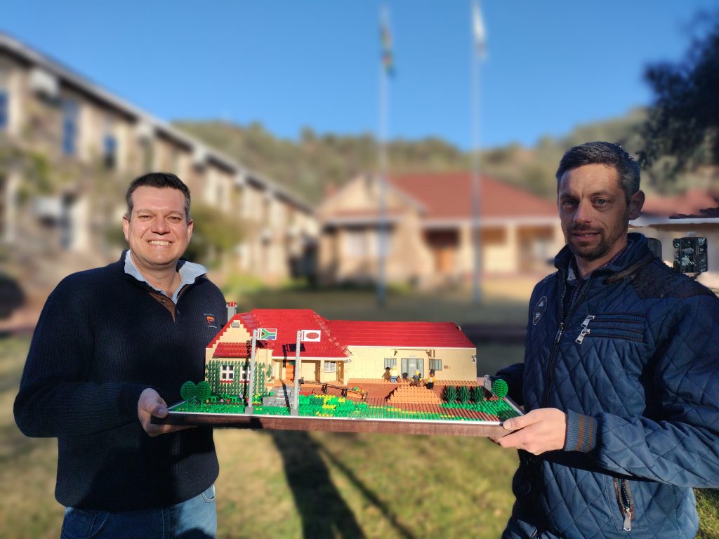 Charl van Schalkwyk en Leon Mentz met die Lego-gebou van Raubex se hoofkantoor.
