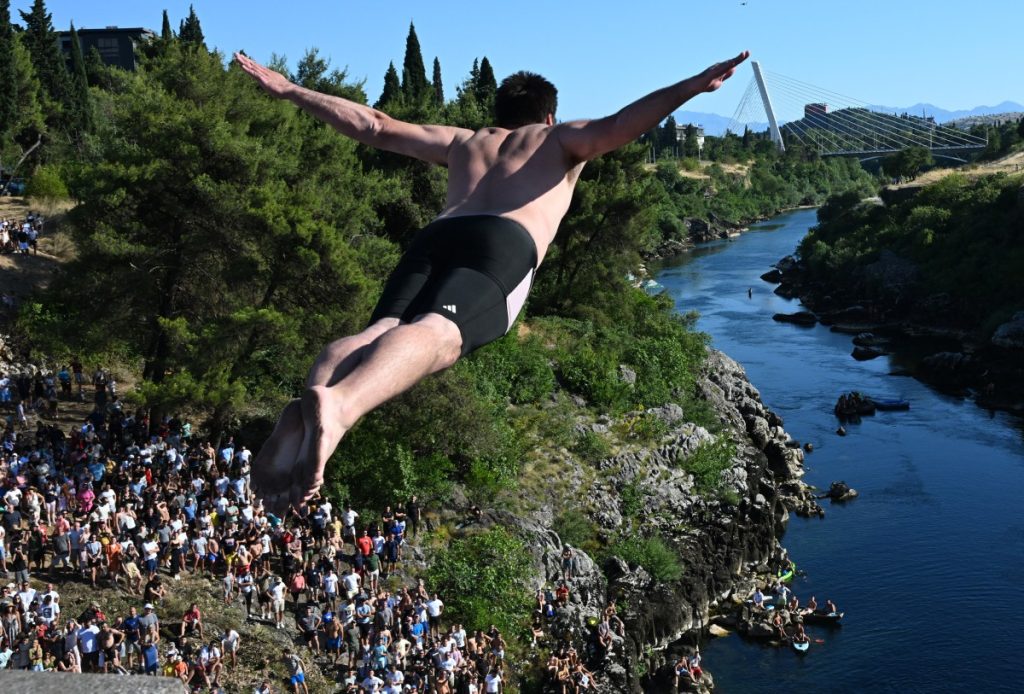 Spectators watch as a high diver takes flight from a 25 meter high bridge into the Moraca River, during a competition in Podgorica.