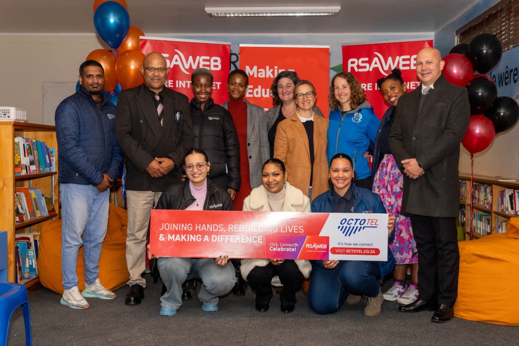 People standing in front of sponsorship banners.