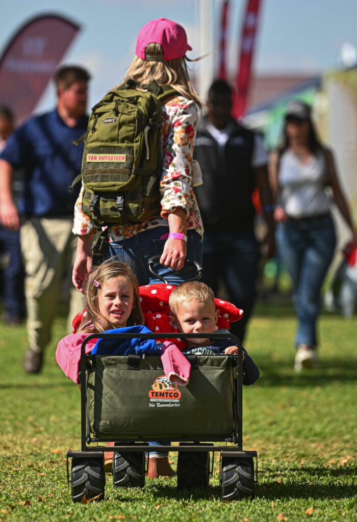 ’n Ma trek haar twee kinders in ’n waentjie by Nampo in 2022.