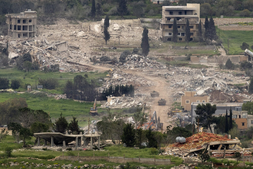 Israelse tenks beweeg tussen die puin van huise in die suide van Libanon, soos gesien van die Israelse grens in die noorde van Israel. 