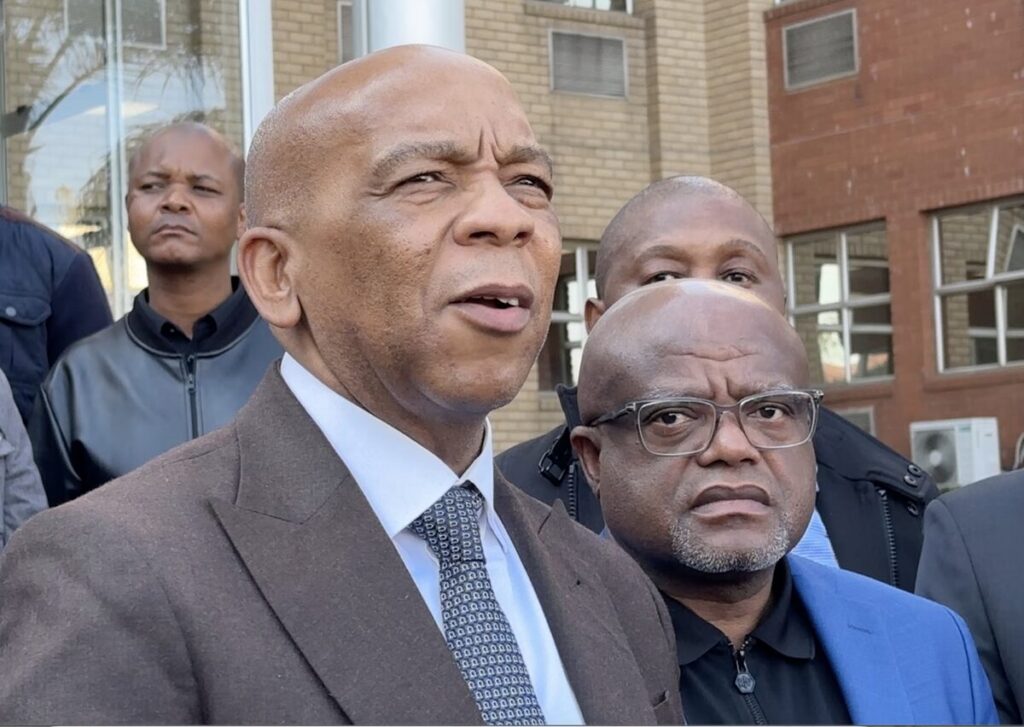 Dr. Kgosientsho Ramokgopa, minister van elektrisiteit, spreek joernaliste toe buite City Power se hoofkantoor in Booysens, Johannesburg, ná 'n vergadering met Dada Morero, burgemeester van die metro (regs).