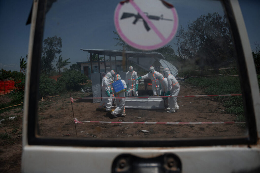 Vrywilligers van die DRK se Rooi Kruis vergader rondom die kis van ’n slagoffer van die Ebola-virussiekte by die Rwampara-gesondheidsentrum in die Ituri-provinsie.