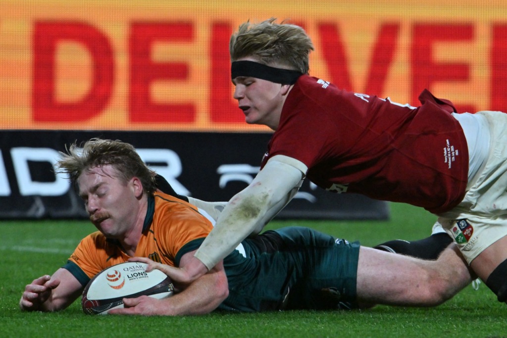 Britse en Ierse Leeus se Henry Pollock druk ’n drie terwyl Harry McLaughlin-Phillips hom probeer keer.
