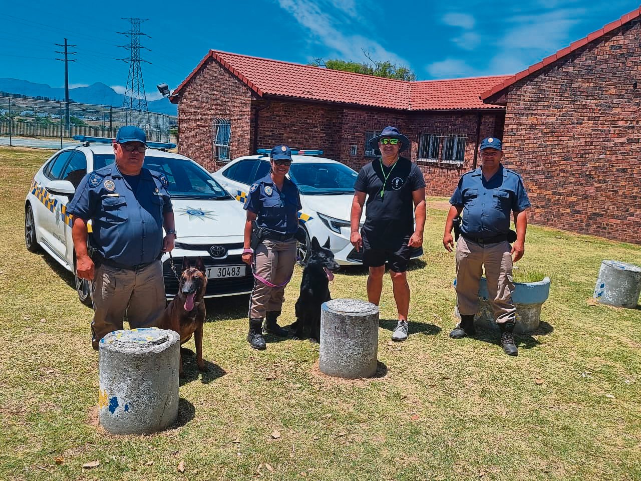 Konst. Abraham Danster, sers. Daniela Swartz en konst. Theodore Williams van die Stad van Kaapstad se Metro-polisie saam met Jerome Hendricks en die polisiehonde tydens ’n honde-skou vir die seuns. 