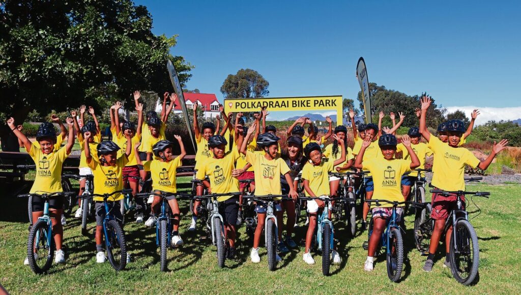 Kinders betrokke by die Anna-stigting, hier met stigter Anna Brom, spog met die 49 nuwe bergfietse wat aan die stigting geskenk is.