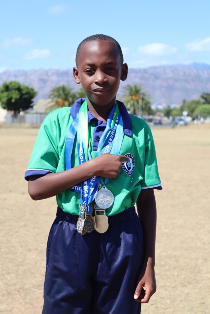 Micah Matava pointing to the  Altena Primary School badge