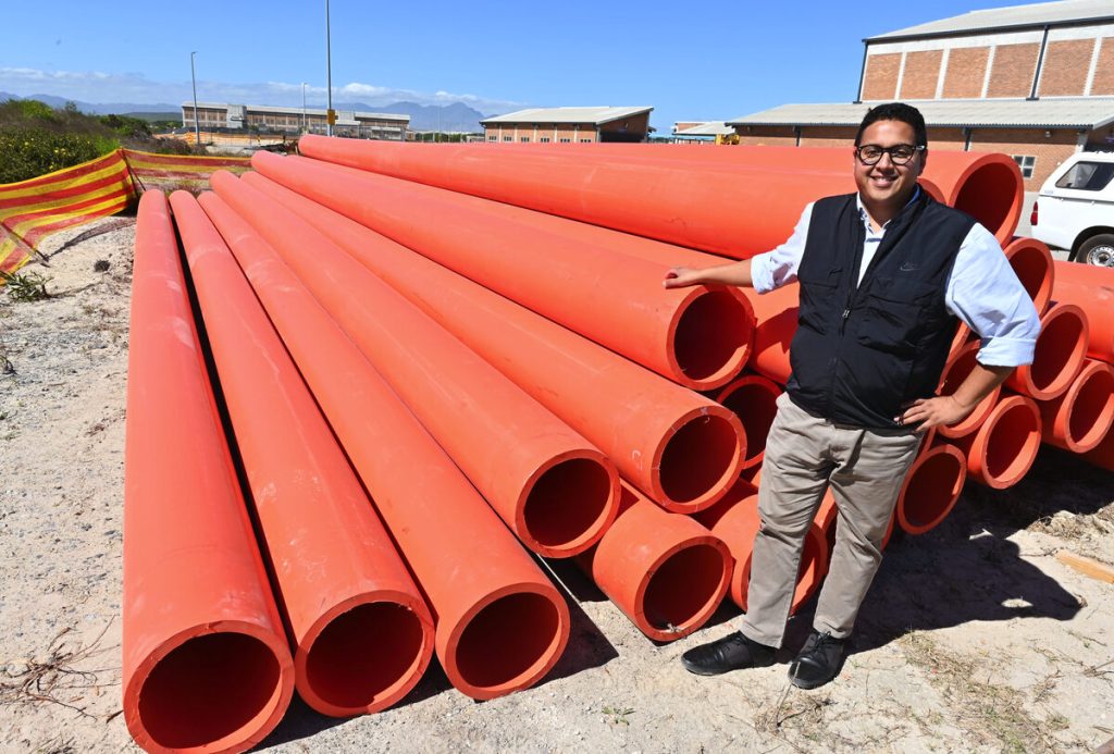 Councillor Zahid Badroodien inspects orange treated effluent pipes at the Zandvliet Pump Station site.