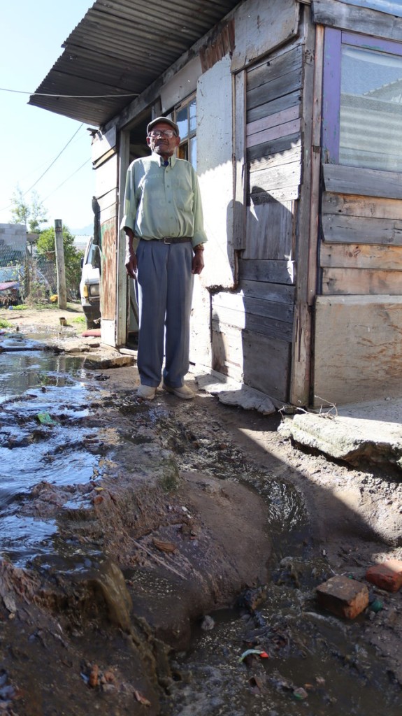 Oupa by die rioolblokkasie buite sy huis in Sir Lowry’s Pass.