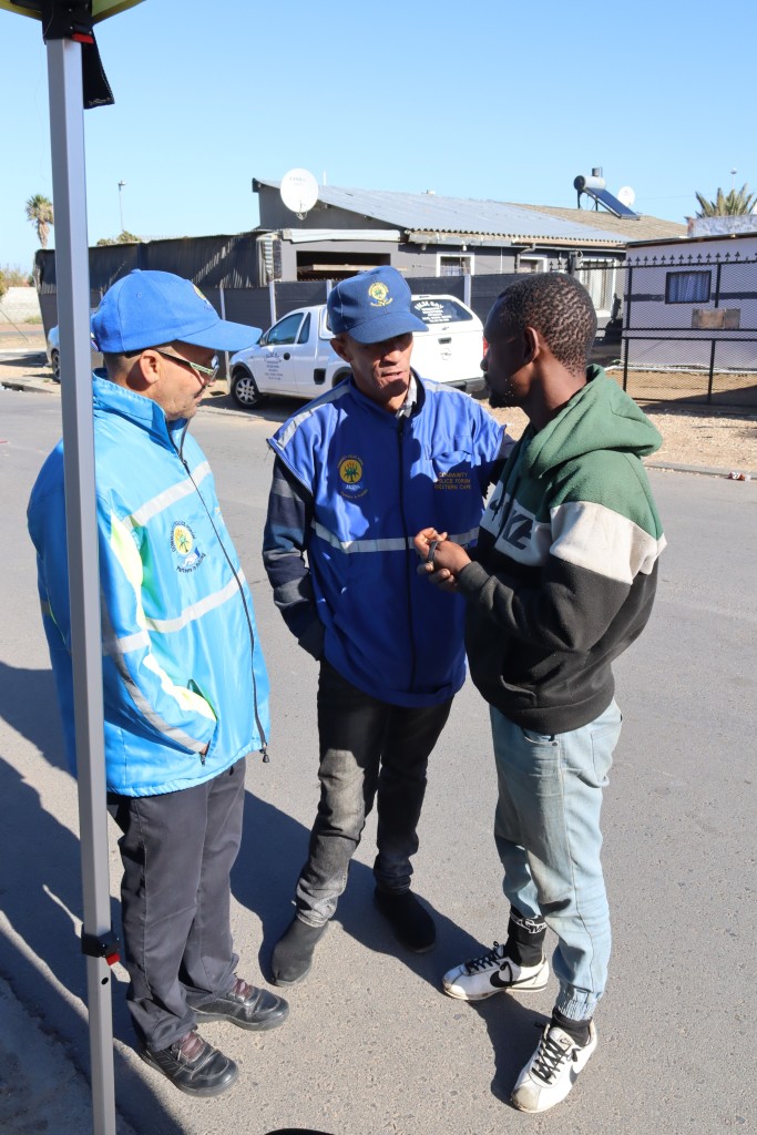 Danfred Kleinschmidt en Niklaas Thysen van die Strand-GPF gesels met Janetun Loston oor gemeenskapsveiligheid tydens die imbizo.