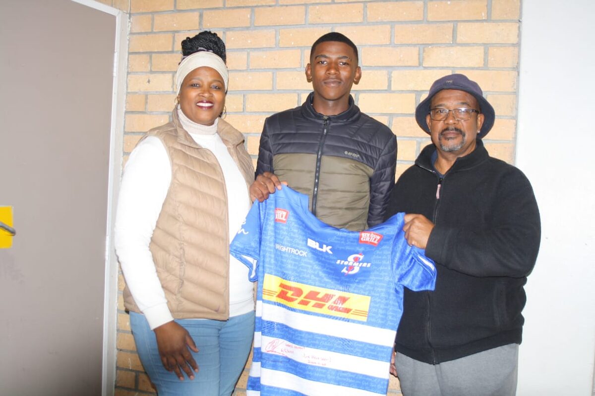 Joe Adams (regs) met Maria en Torris Adams nadat hy R2 550 gebied het vir Ben Dixon se getekende Stormers-trui.