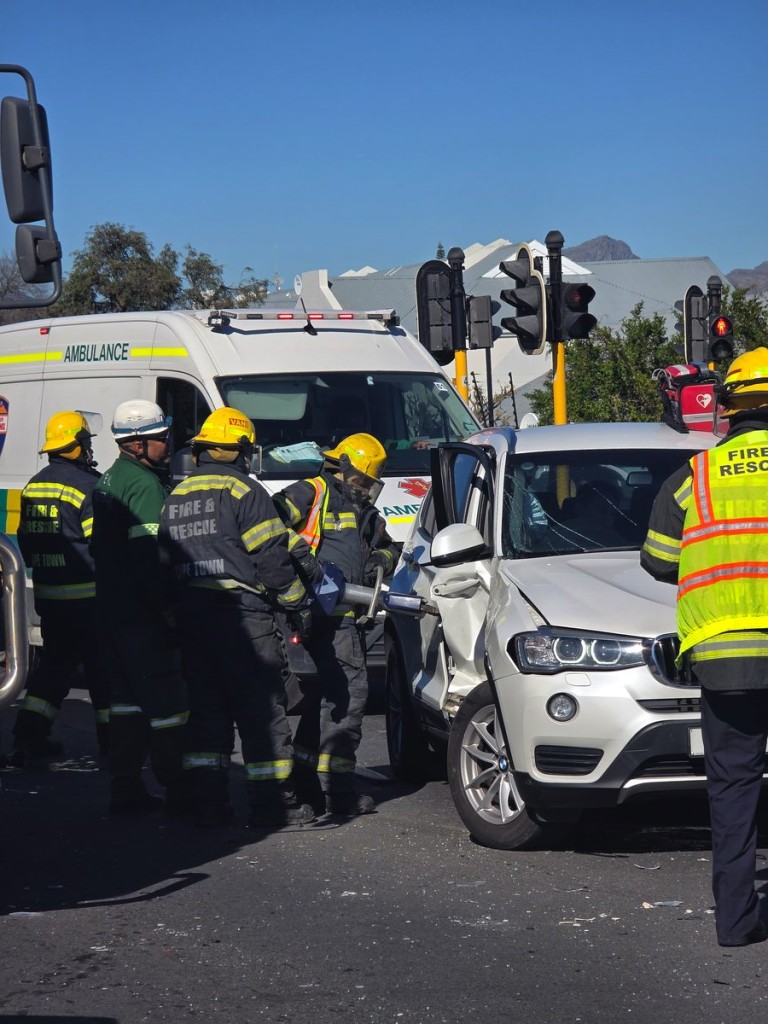 Fire and Rescue personnel using hydraulic equipment to free Chris Dicks from his wrecked BMW SUV.