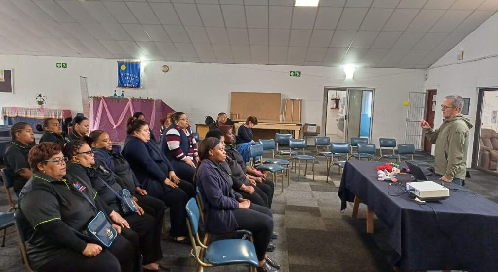 Staff at Phambili during mental health training, seated on deteriorating chairs that prompted R20 000 safety campaign.