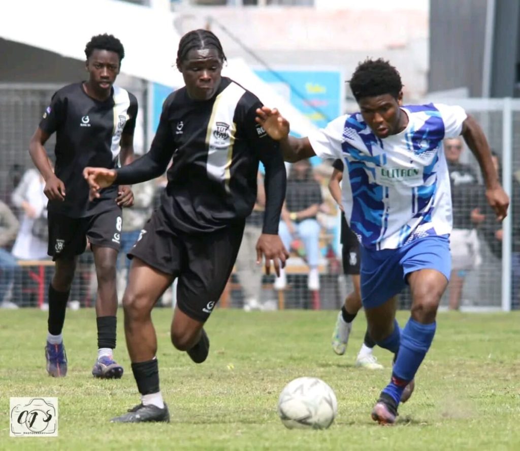 Leeroy Chipato Virimayi (blue) n attack for De Beers AFC.