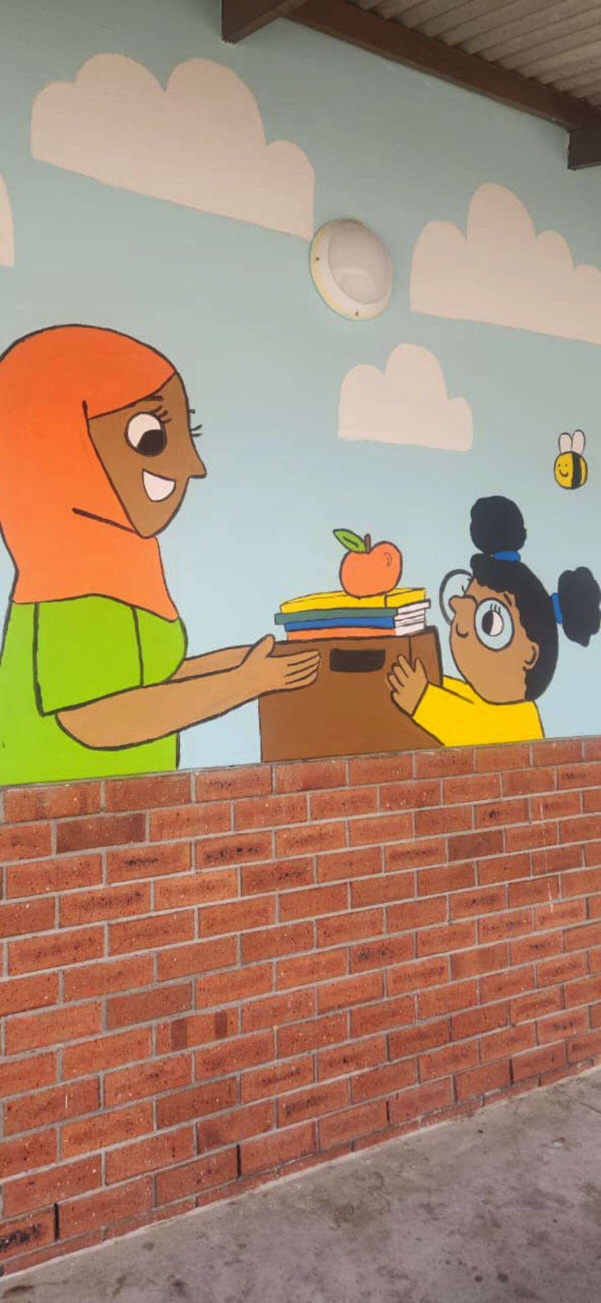 Kleurvolle tekening op muur wat diverse karakters en kulture uitbeeld