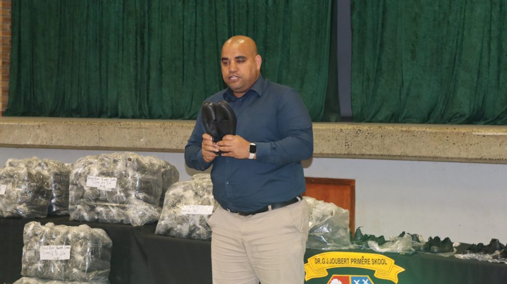 Deputy mayor Eddie Andrews displaying eco-friendly school shoes