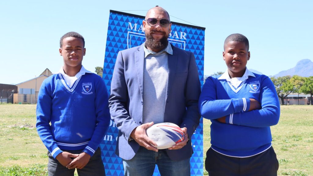 Wesley Williams (middel) met Macassar-rugbyseuns Zane Rabie (regs) en Caleb Pick (links) na R5 000-skenking