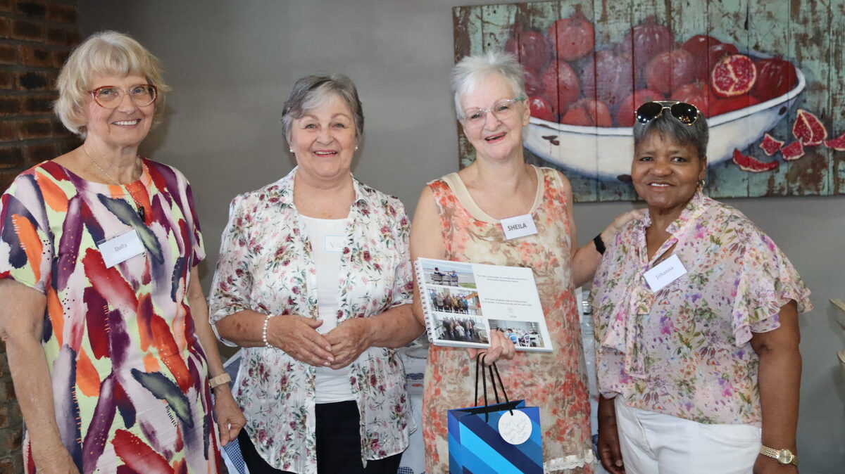 Four senior citizens posing together smiling at Memory Album launch celebration event