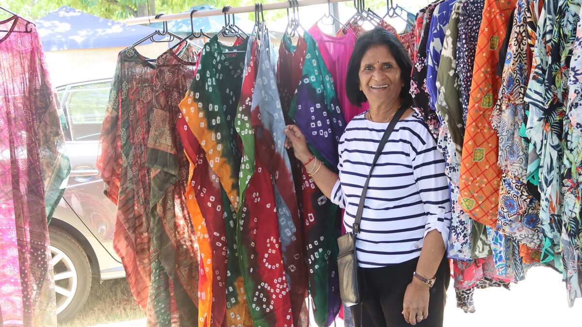 Laksmi Gangen from Lukkie's Originals displays tailor-made garments at her market stall.