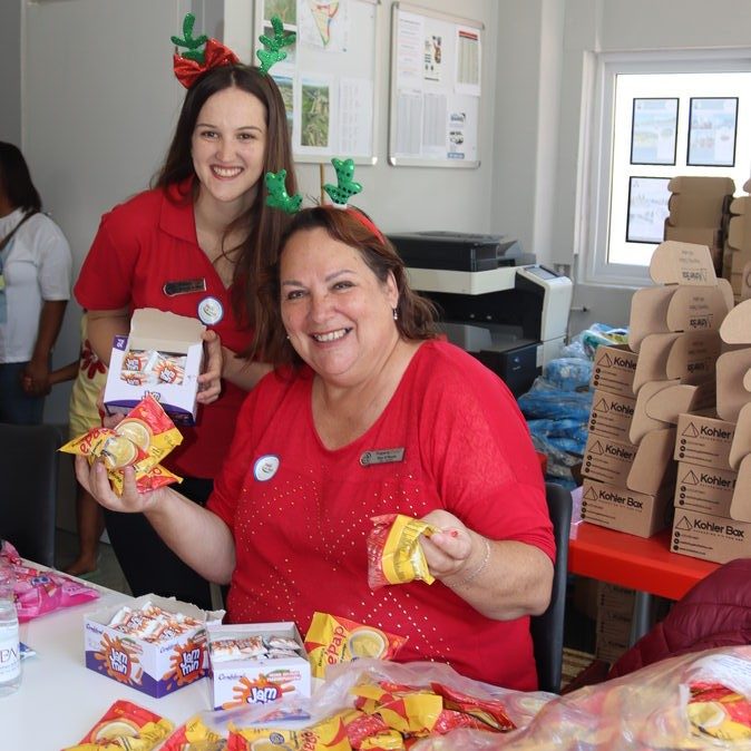 Rachael da Silva and Elsa O'Neale showing treats and essentials for Christmas boxes.