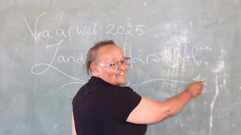 Christina Coetzee skryf vir die laaste keer op die klaskamerbord voordat sy aftree.