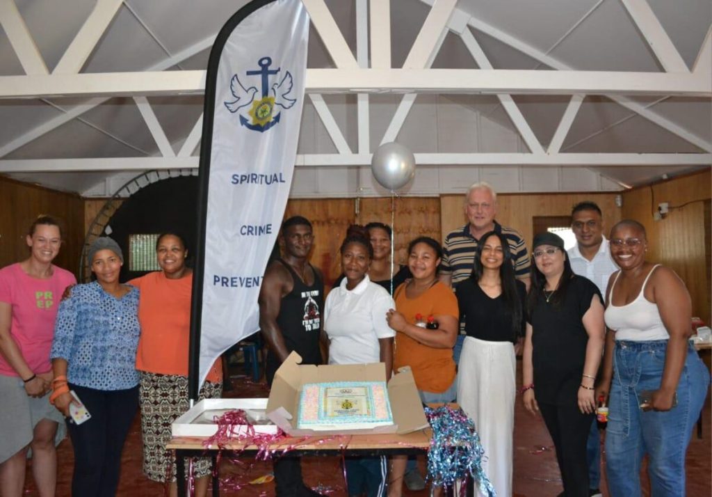 Members of police crime prevention unit and centre staff with children's celebration cake.