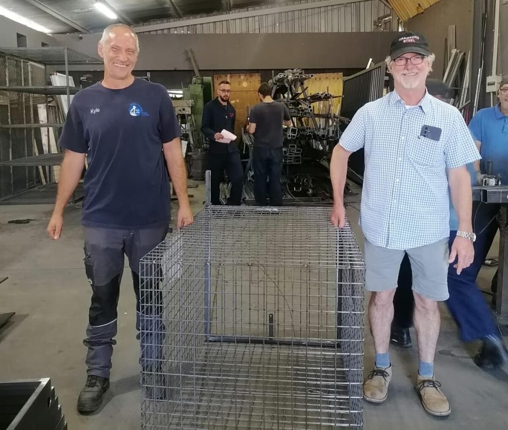 Kyle Girodo (left) and Dicky Crawford with the custom-built animal trap.