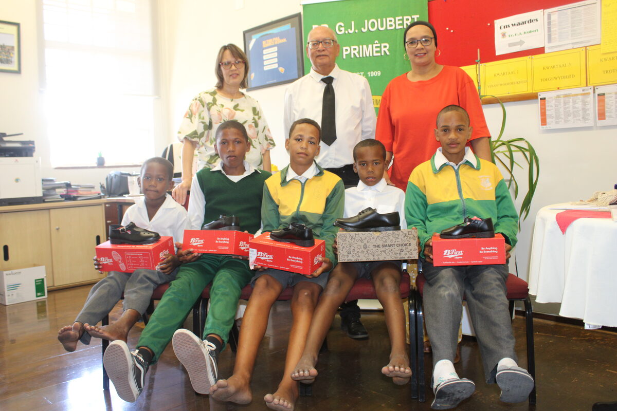 At the handover of shoes at Dr GJ Joubert Primary (behind, from left) are Cindy Coetzee and Vernon Boswell (Libra Trust) and school principal Tauhira Fanie. Seated in front are learners Liam Scratch, Ruan Muller, Junaid Coetzee, Liam Arendse and Raven du Preez. Photo: Yaseen Gaffar