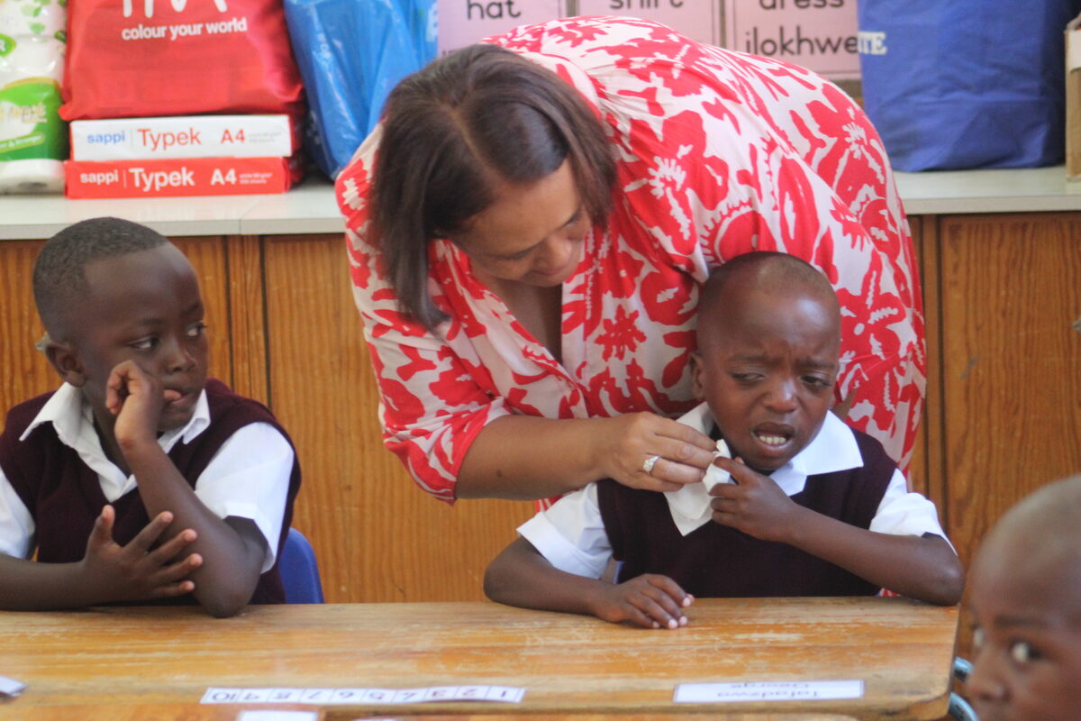 Klein Tafadzwa George huil in die klaskamer terwyl juffrou Rushda Biscombe hom probeer troos