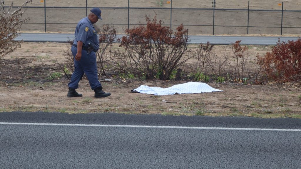 Polisiebeampte ondersoek die toneel waar 'n voetganger dood op die N2 in Macassar gesterf het.