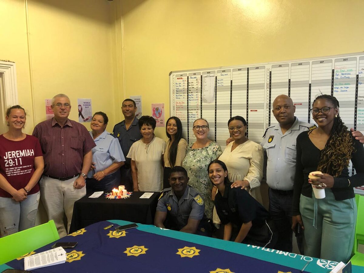 Gordon's Bay police officers standing around lit candles in honour of cancer victims during World Cancer Day event.