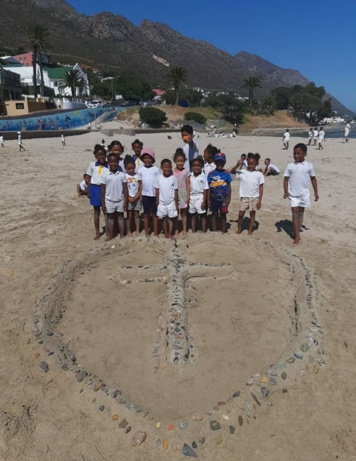 Leerders maak kunswerke van sand en rotse by Gordonsbaai se strand