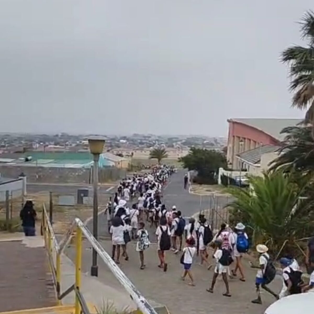 Leerders stap saam na Gordonsbaai se bekoorlike strand.