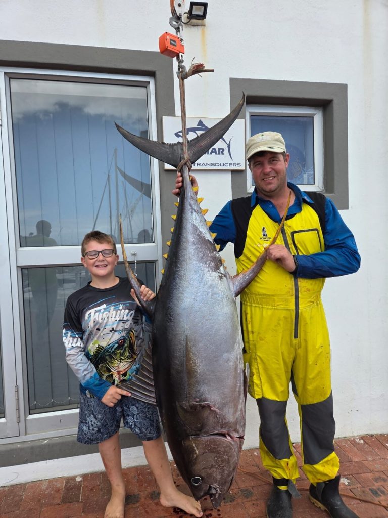 Young angler DeWet van der Walt and his father, Dirk, pictured alongside the monster yellowfin tuna catch.