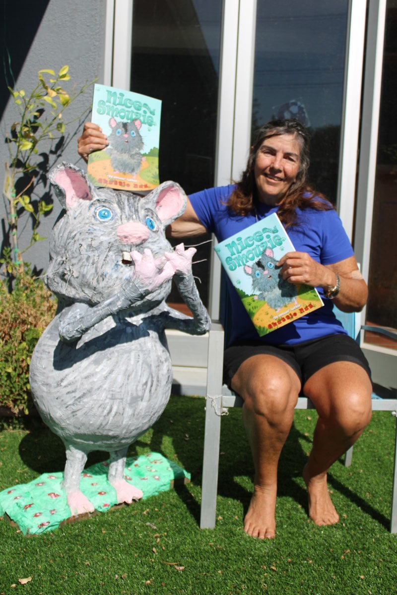 Children's book author Denise Letts proudly shows off her book beside her own papier-mâche representation of its lead character, Skuttle Nut.