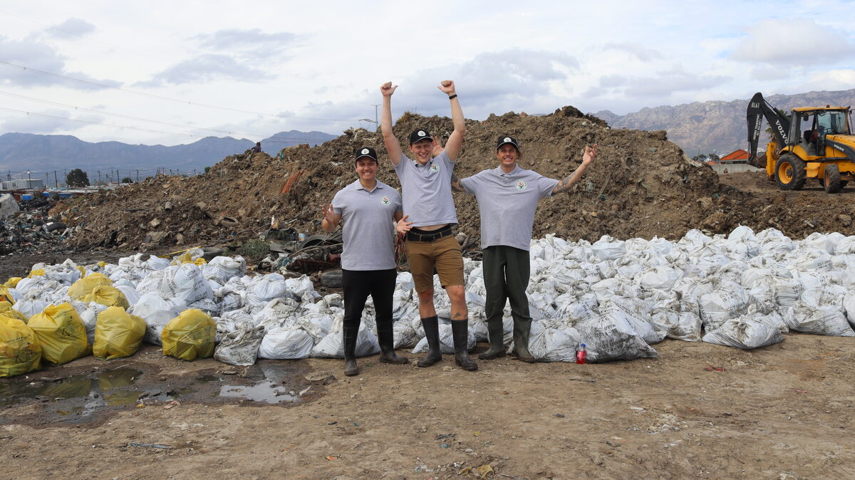 Three men with large collection of waste bags removed from river cleanup