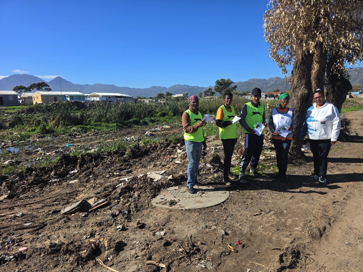 Oasis-vrywilligers en projekbestuurder Getruida Hendricks poseer saam langs die Soetrivier in Strand.