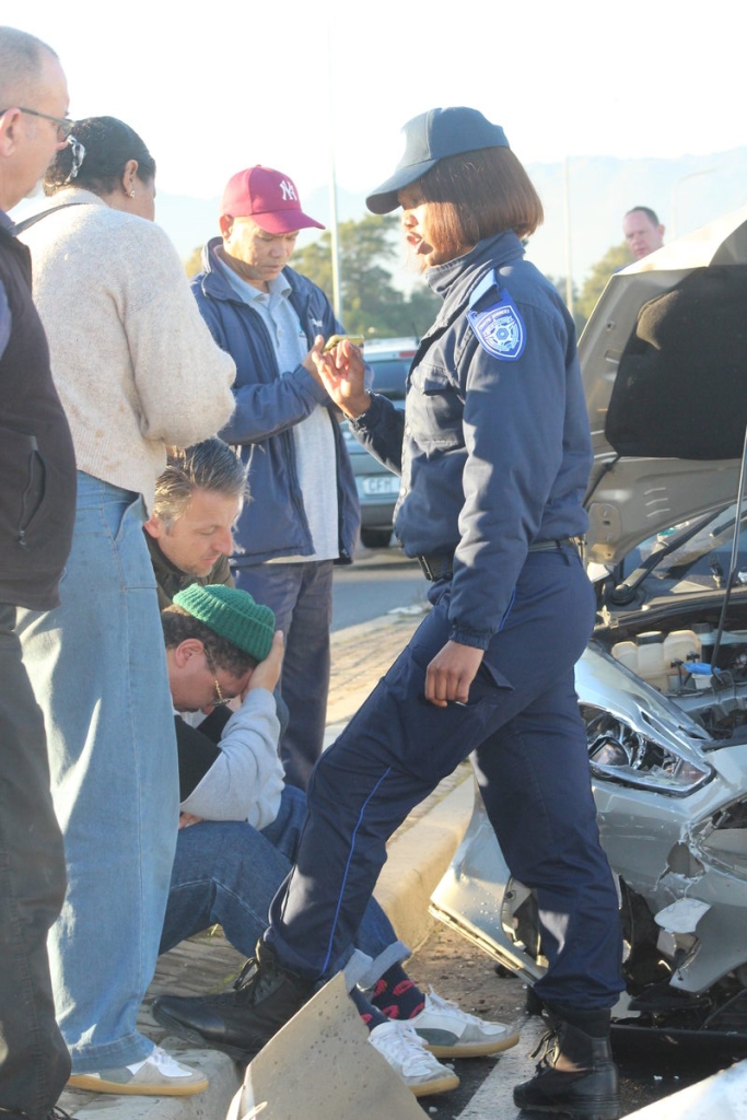 Tarren Olkers, visibly shaken, beside his damaged Ford Fiesta after the N2 multi-vehicle crash.