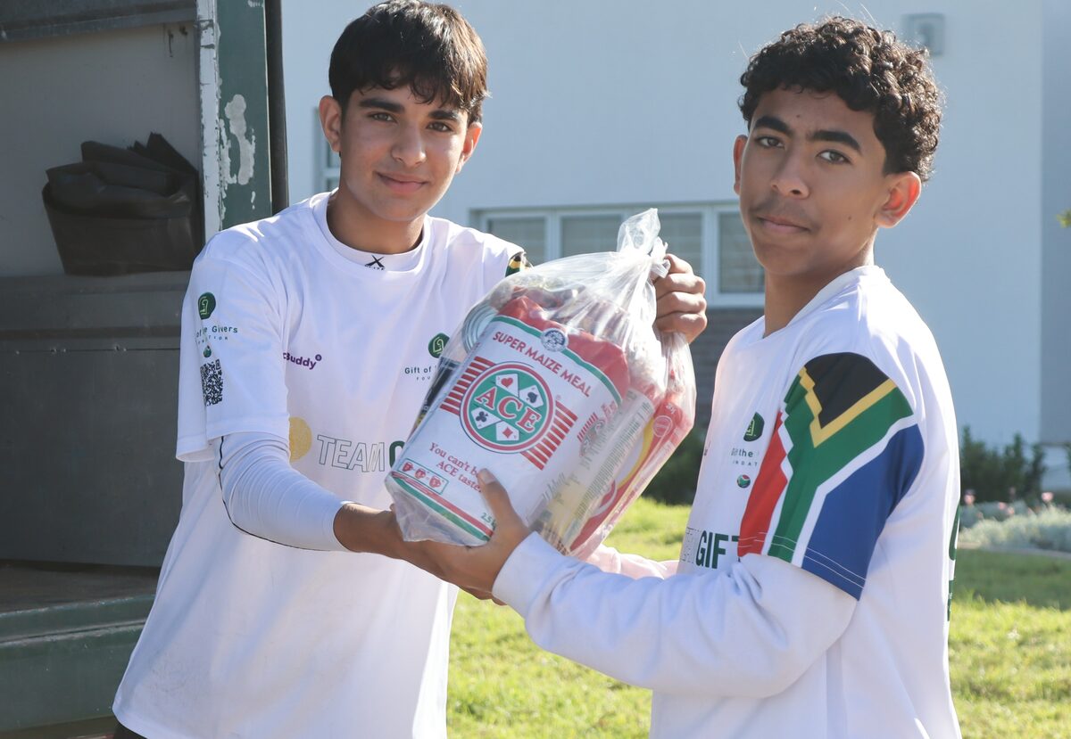 Rondebosch Boys' High School learners Qaanit Waggie and Umar Paruk unloading relief parcels at Masifunde Primary.