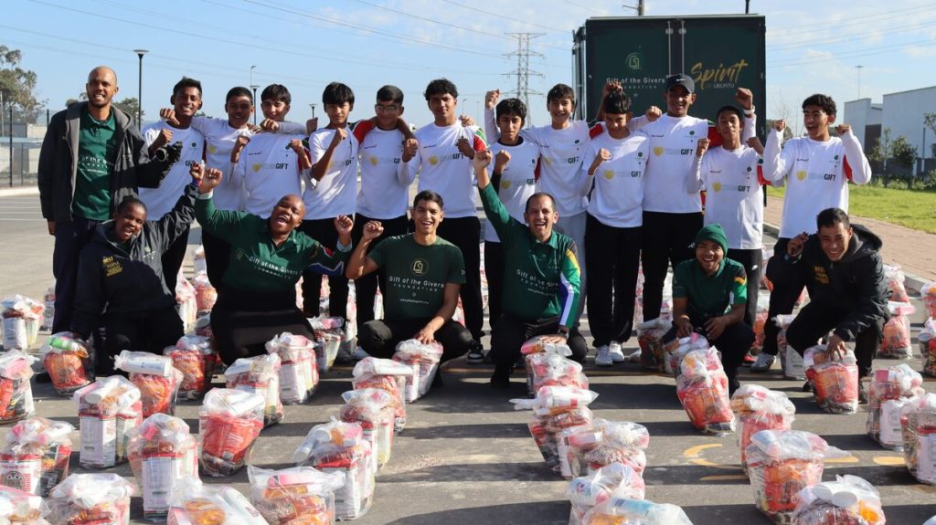 Volunteers and Rondebosch Boys' High School learners at food parcel distribution in Lwandle school.