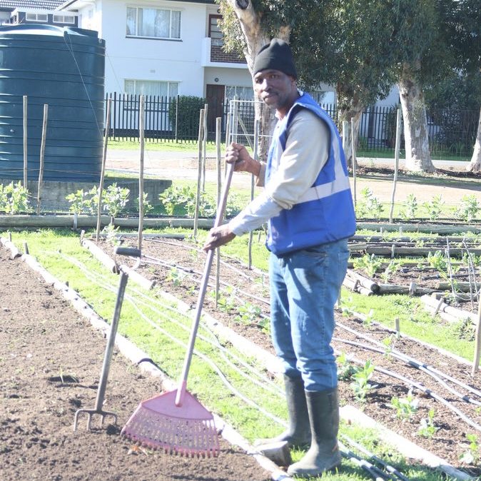 Christopher Mroji works with a rake at Somerset West Village Garden programme