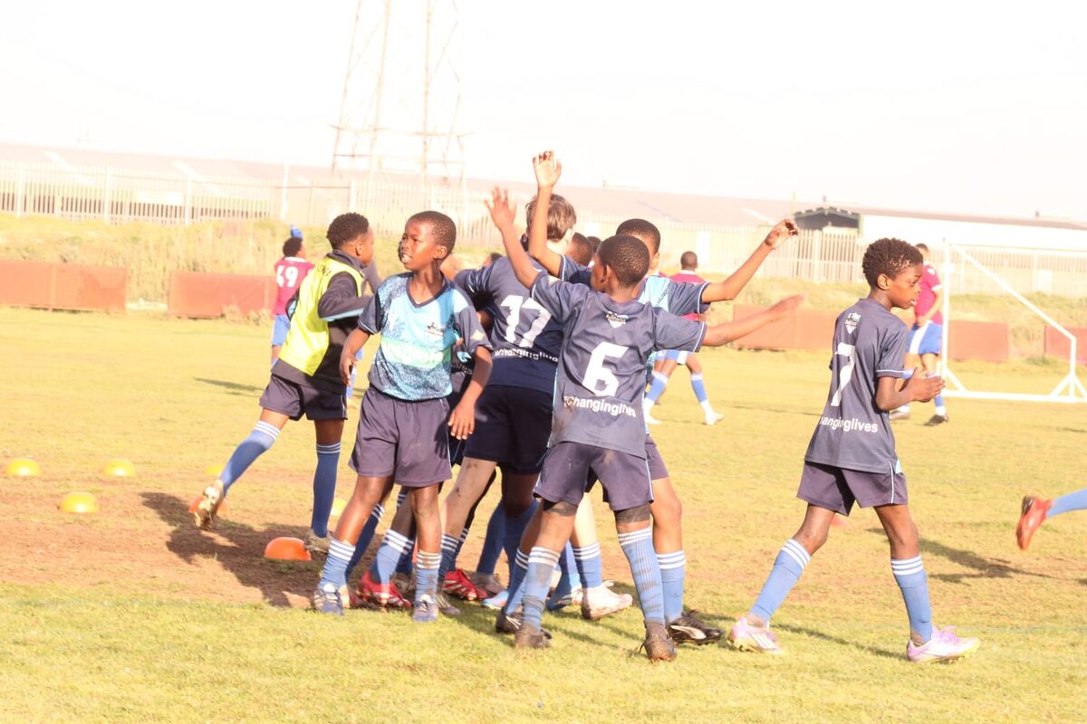 Young Bafana's under-12 boys celebrate after scoring a goal.