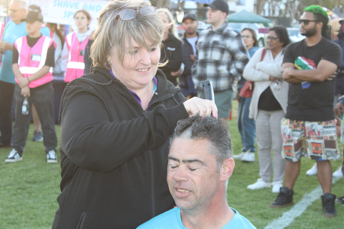 Helderberg Relay for life organiser Lucille Kruger shaves off the hair of EJ Sanger.