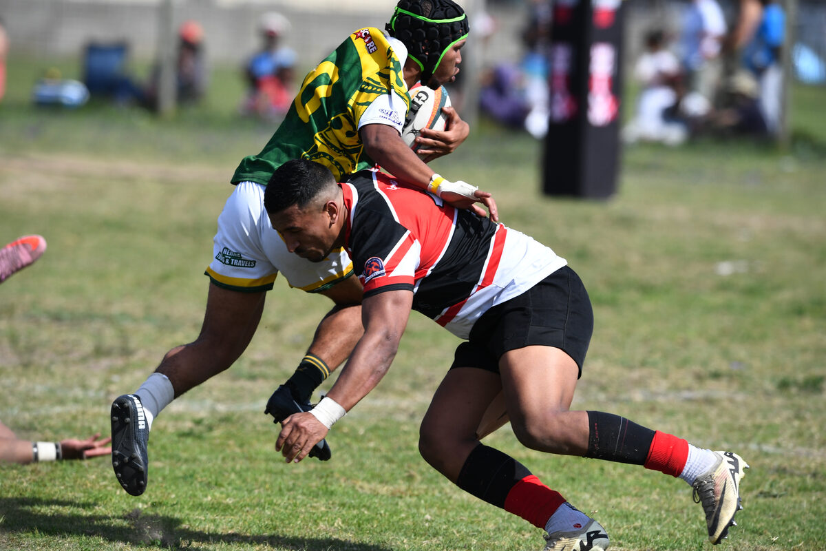 Strand United's Byron Adams putting in a big hit on  Eerste River's Devon Botha.