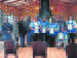 Vrywilligers in blou staan Groot-Drakenstein-polisie by