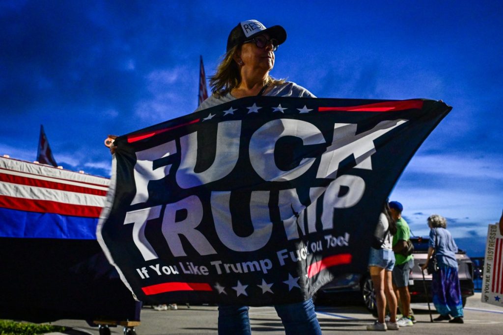 A woman holds a flag during a protest near the Mar-a-Lago residence of US President Donald Trump as part of the 'Good Trouble Lives On' national day of action against the Trump administration.